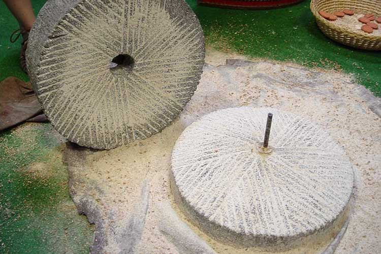 Hand grain mill with slightly conical grindstones